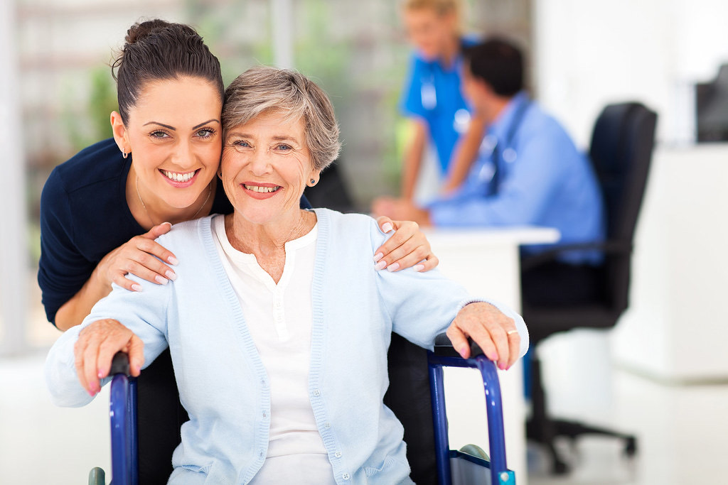 A smiling senior woman with her daughter at a GP surgery